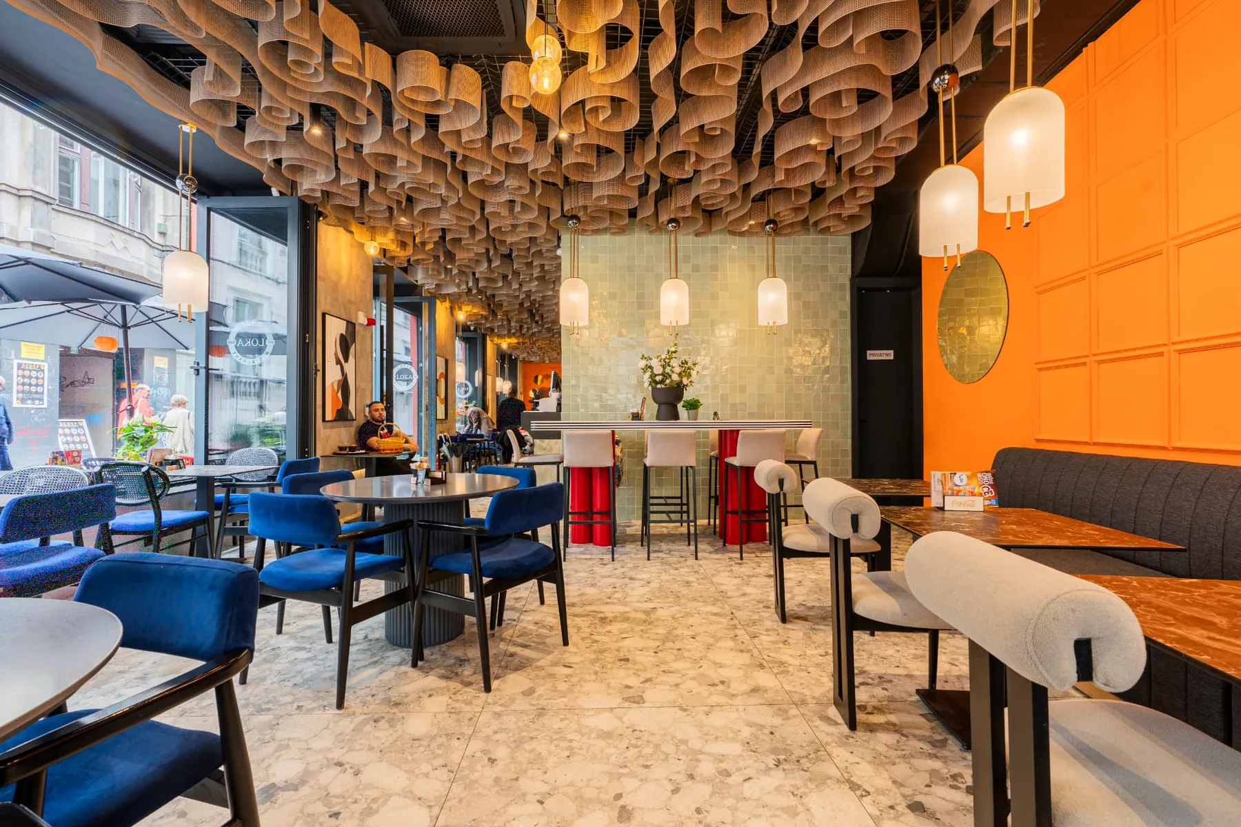 Šank LOKA restorana sa zelenim pločastim zidom